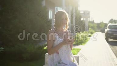 一位年轻的金发女郎用<strong>手机</strong>给朋友写信，一位女士在炎热的夏天在街上<strong>拿</strong>着一部<strong>手机</strong>