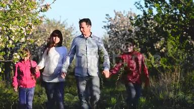 <strong>孕妈妈</strong>，爸爸和孩子走着朵朵春园.. 幸福的家庭在花园里休息