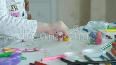 一个快乐的小女孩从一个容器里拿出五颜六色的塑料，<strong>桌面上</strong>摆着数字和彩色铅笔