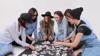 一群女人坐在地板上。 女人选择图片中的服装风格。