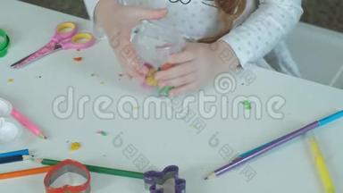 一个快乐的小女孩从一个容器里拿出五颜六色的塑料，桌面上摆着数字和彩色铅笔