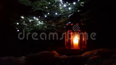 圣诞灯笼特写。 圣诞红灯笼矗立在一棵圣诞树下。 灯笼上燃着蜡烛