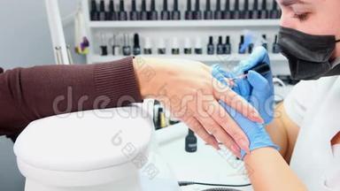医生正在美容院给顾客的指甲美容院给客户的指甲涂上<strong>凝胶</strong>抛光剂。 竖起<strong>钉</strong>子。 假人