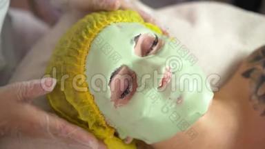 在美容院，美容师给客户戴上海藻酸钠面膜。 皮肤增光、保湿、营养