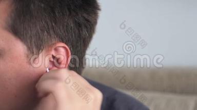年轻人用棉签擦耳朵