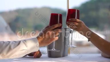 这对情侣在餐厅喝着酒碰杯的近景。 没有脸。