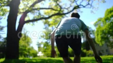 阳光明媚的夏日，一个快乐体贴的梦想家在花园里散步，坐在公园的绿草上。