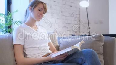 正经的年轻女子坐在沙发上看书