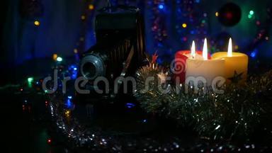 三支新年`蜡烛和一台旧相机。 摄像机围绕物体的运动。 背景模糊。