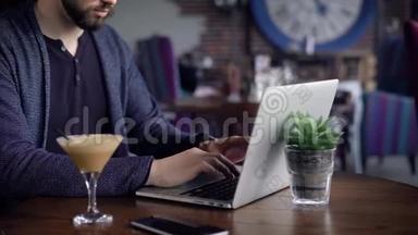 一个眼睛不好的年轻作家在他所在城市的咖啡馆里为一台笔记本电脑`作品，一个男人在键盘上打印诗歌