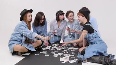 一群女人坐在地板上。 女人选择图片中的服装风格。