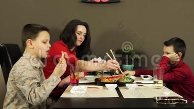 一群快乐迷人的朋友和孩子们一起在寿司店聊天吃寿司