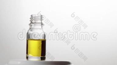 玻璃瓶与吸管精油滴在缓慢的运动。 自然疗法