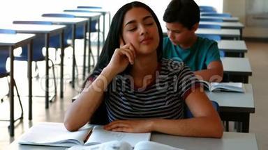 睡觉的女孩在教室里学习时在桌子上放松