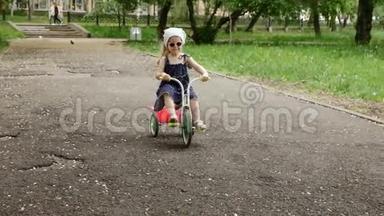 小女孩骑三轮车或三轮车慢动作。
