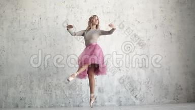 年轻的芭蕾舞演员正在跳古典芭蕾。 芭蕾舞演员穿着粉红色的芭蕾舞裙和金色的尖