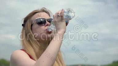 肖像年轻女子在<strong>炎热的夏天</strong>从塑料瓶里喝冷水