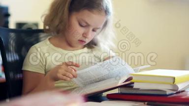 一个女<strong>学生</strong>坐在桌子旁看书。 家庭<strong>教育</strong>。 儿童<strong>教育</strong>。 知识日