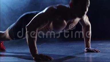 举重运动员正在锻炼，从地板上握手。 <strong>黑烟</strong>背景。 剪影