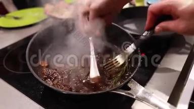 厨师用平底锅煮炒肉排，从盘子里蒸出来，食物大师级，有选择的重点