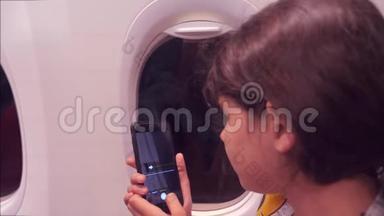 <strong>航空飞机</strong>概念。 年轻女孩正坐飞机在下面的智能手机之夜城市拍照
