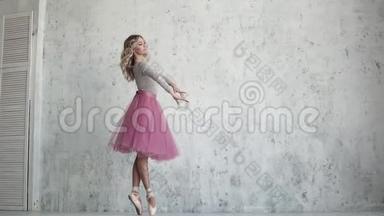 芭蕾舞演员穿着尖角鞋在脚趾上旋转。 美丽的年轻芭蕾舞演员。 慢动作的皮鲁埃特