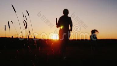 日落时分，女人和女孩在夕阳下慢跑，剪影映衬着夕阳