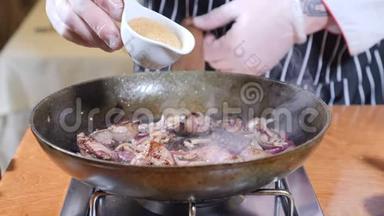 在餐厅的一个热煎锅上加入肝片的厨师烹饪弗拉姆贝式<strong>菜肴</strong>。 手戴手套