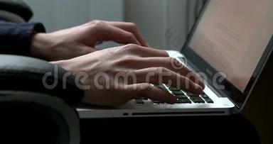 侧视图一名男子在笔记本电脑上打字的手持录像