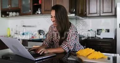 女孩用笔记本电脑在厨房聊天在线年轻女子工作室现代室内