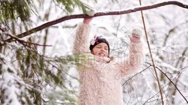 一个穿着粉红色皮<strong>毛大衣</strong>的女孩正在冬季公园玩。 积极休息，孩子们`休闲，下雪