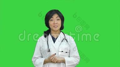 亚洲女医生展示一瓶药片，在绿色屏幕上呈现药丸，Chroma键