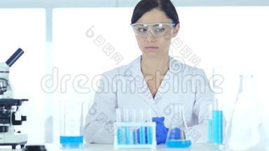 坐在实验室里戴防护眼镜的科学家
