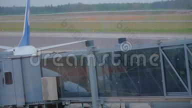 两名乘客通过空中天桥登上飞机的剪影。