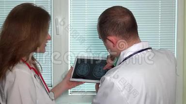 医生在平板电脑中观察头部磁共振成像
