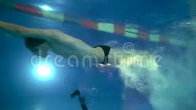 水下景观给美丽的专业游泳运动员潜水到游泳池和游泳以上的摄影师。 水下