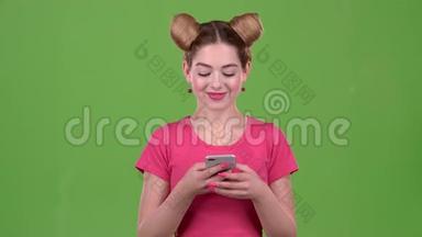 一个粉红色<strong>话题</strong>的青少年在电话上打印一条信息。 绿色屏幕。 慢动作