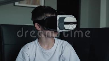 一个快乐的男孩戴着虚拟现实眼镜在家里玩游戏看电影。虚拟现实眼镜新技术
