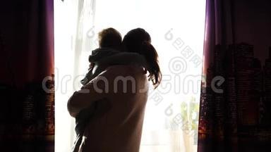 母亲双手抱着一个小孩子.. <strong>阳光透过窗户</strong>。 宝宝的欢声笑语..