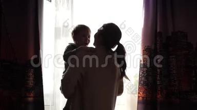 母亲双手抱着一个小孩子.. <strong>阳光透过窗户</strong>。 宝宝的欢声笑语..