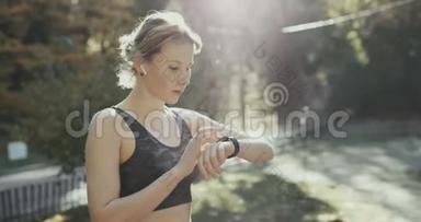 使用智能手表的无线耳机和<strong>晨曦</strong>运行的健身妇女