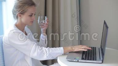 女人在电脑上工作<strong>喝酒</strong>