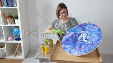 女人做流体艺术丙烯酸绘画。 创意宇宙艺术品嬉皮壁纸蓝色与<strong>创作者</strong>的手。