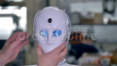 一名技术人员安装了一个机器人的面罩。