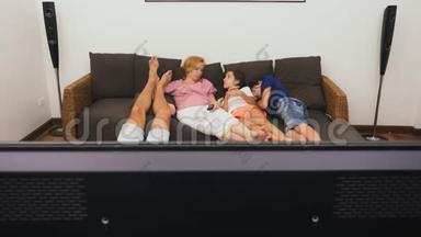 可爱的家人，妈妈，爸爸，女儿和儿子一起在客厅里看电视，在前面睡着了