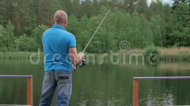 穿着蓝色T恤的人在河边钓鱼
