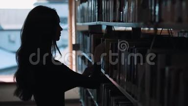 图书馆<strong>书架前</strong>一个女孩<strong>看书</strong>的剪影