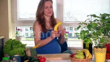 饥肠辘辘、面带微笑、<strong>大肚皮</strong>的孕妇在厨房里摘香蕉