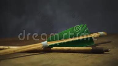 旋转圆木桌上的老<strong>绿色</strong>木箭。 美丽的黑暗<strong>背景</strong>。