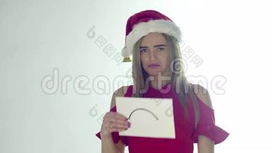 戴着红色圣诞帽的<strong>悲伤</strong>的圣诞妇女抱着一张床单，带着<strong>悲伤</strong>的微笑，孤立在白色的背景上